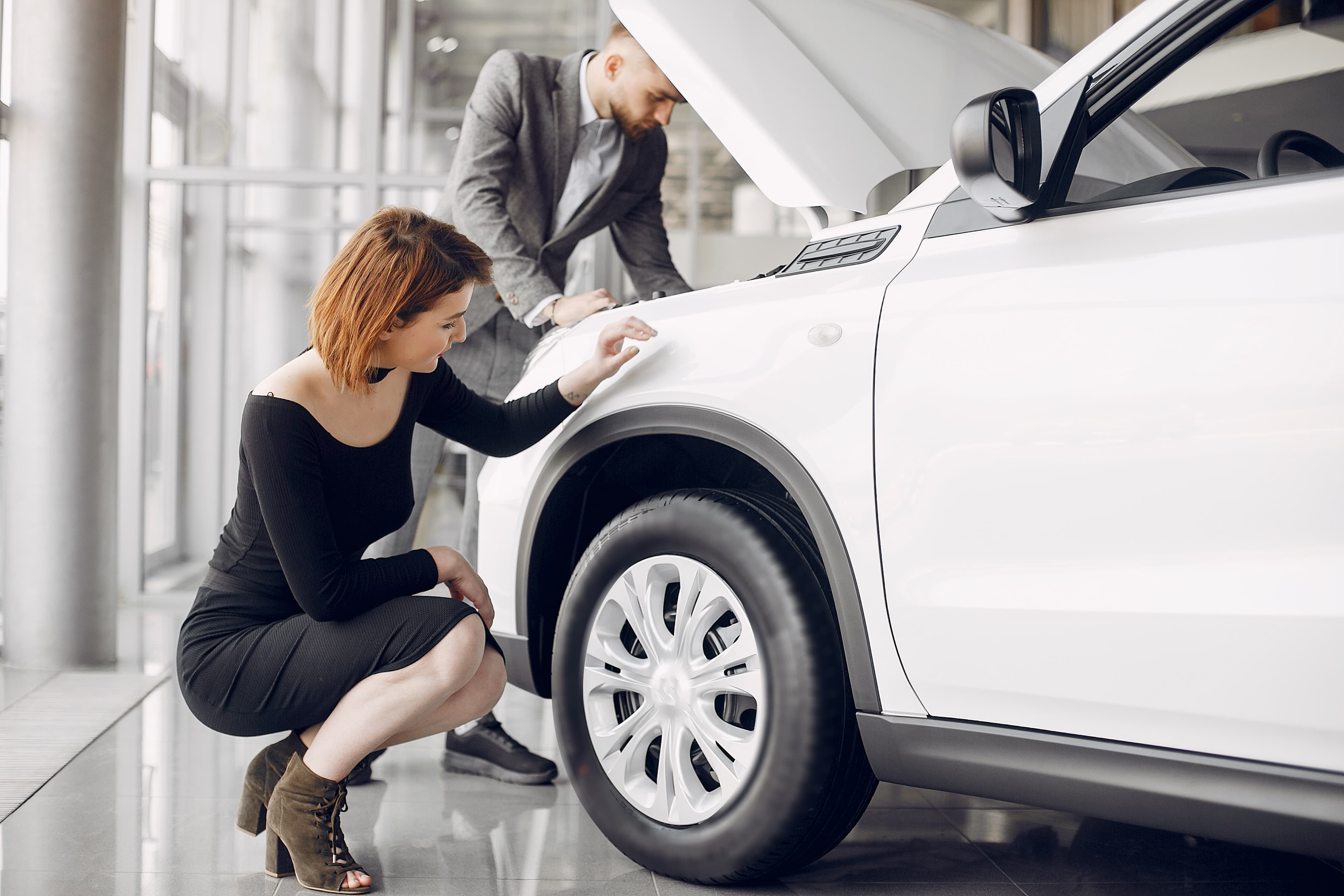 Casal feliz na concessionária com o carro