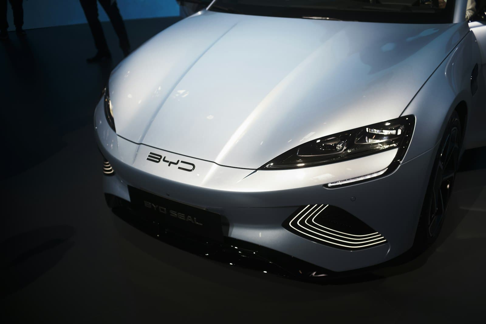 BYD Seal exposto em salão automotivo, com o logotipo da BYD em destaque no capô